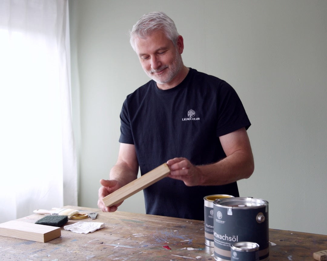 Jörg bei der Anwendung des Lignocolor Hartwachsöls an einer alten Werkbank