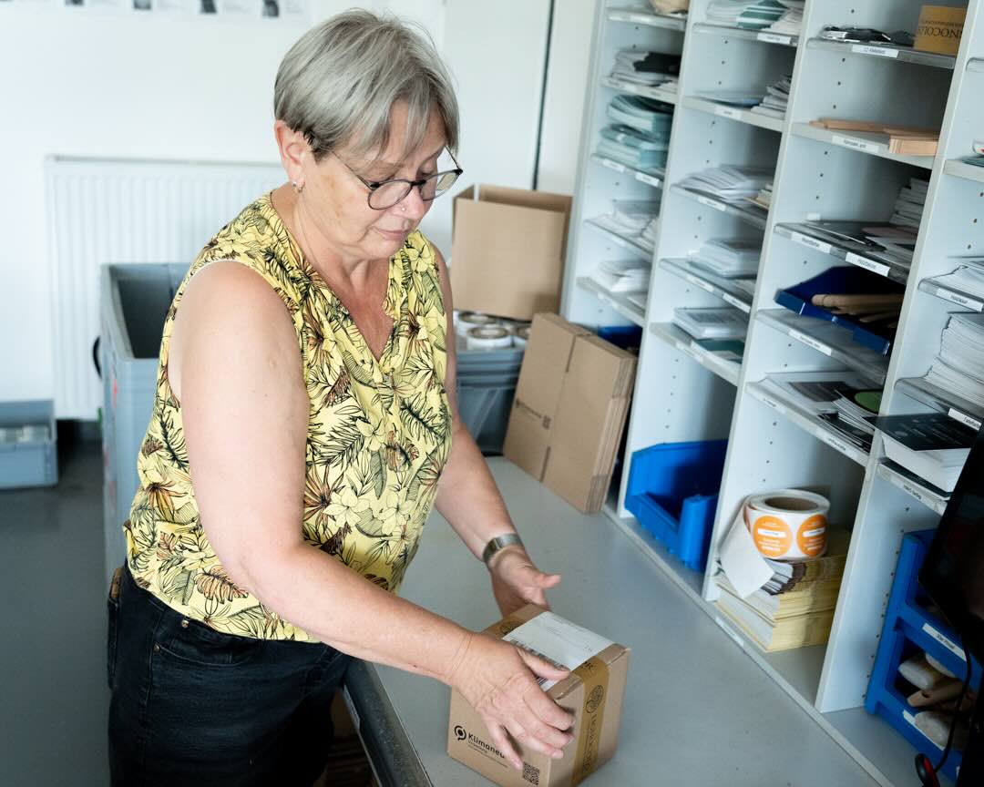 Mitarbeiterin im Versand verpackt gerade eine Bestellung