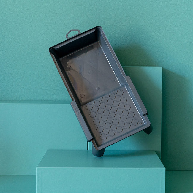 Kleine Farbwanne steht vor grünem Hintergrund