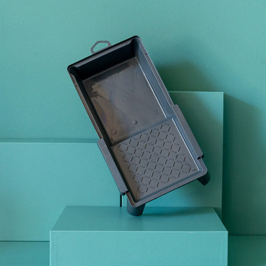 Kleine Farbwanne steht vor grünem Hintergrund