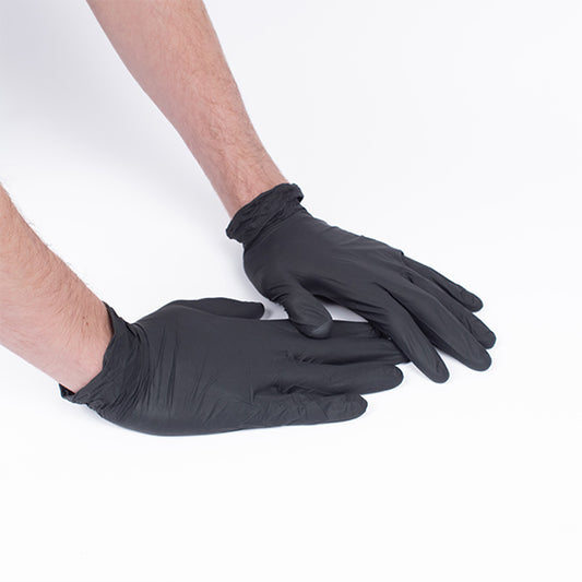 Zwei Hände in schwarzen Nitirl-Handschuhen stützen sich auf weißem Untergrund ab