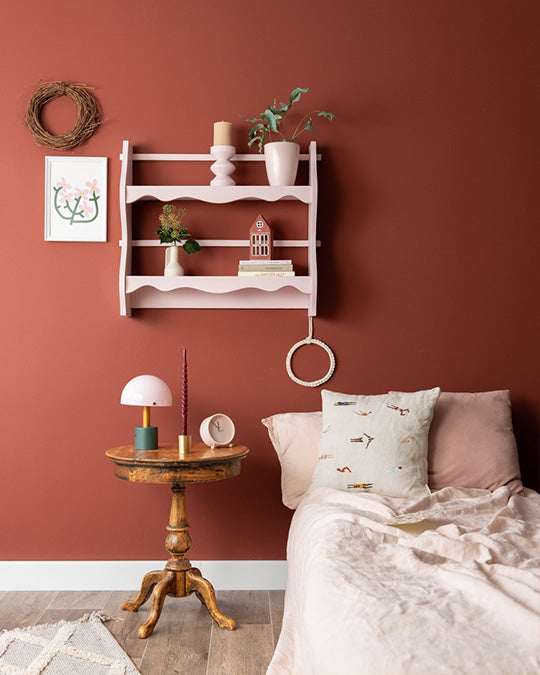 Im dunklen, bräunlichen Rost-Farbton Rusty gestrichene Wand im Schlafzimmer