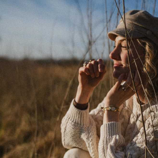 Frau sitzt am Feld in der Sonne