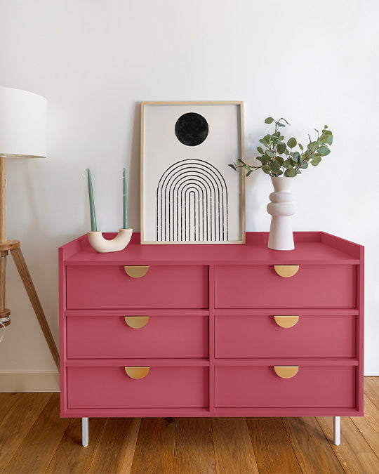 Pinke Kommode vor weißer Wand im Schlafzimmer