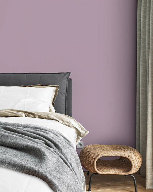 Schlafzimmer Inspiration Bett vor lila Wand in Wandfarbe Violetta von Lignocolor