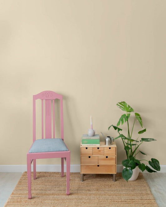 Wand mit violettem Stuhl im Farbton Beige gestrichen.