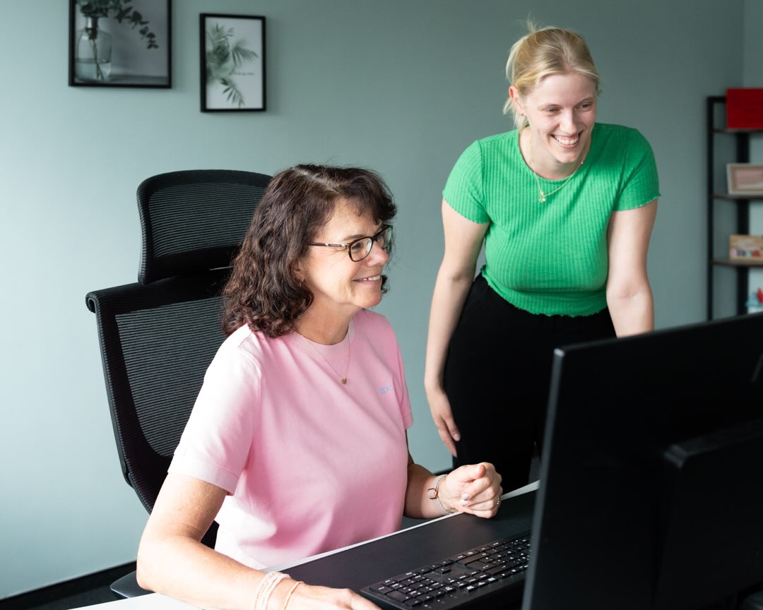Zwei Frauen sind gemeinsam vor dem Bildschirm und sprechen über ein Anliegen
