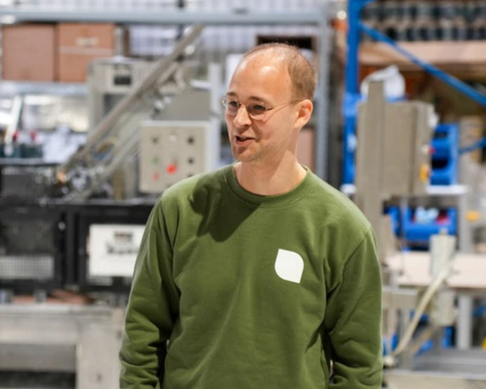 Marcel Prieto, der Gründer von Lignocolor steht erklärend in der Lagerhalle der Farbenmanufaktur