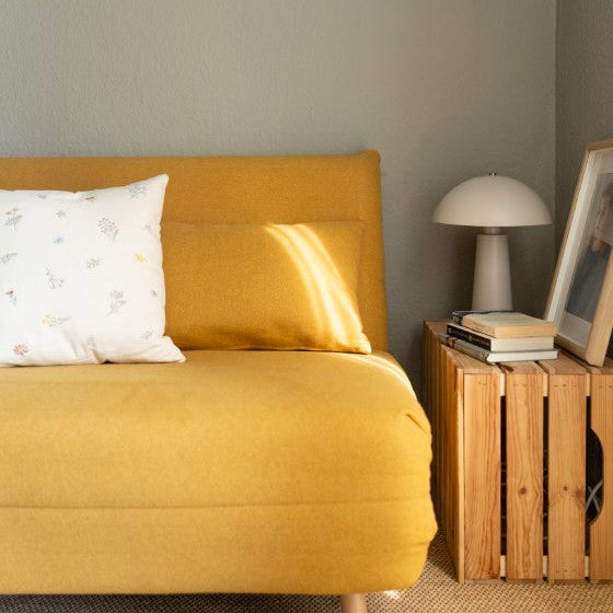 Wohnzimmerwand hinter gelbem Sofa im leicht gelblicheln Grauton Nature Grey gestrichen