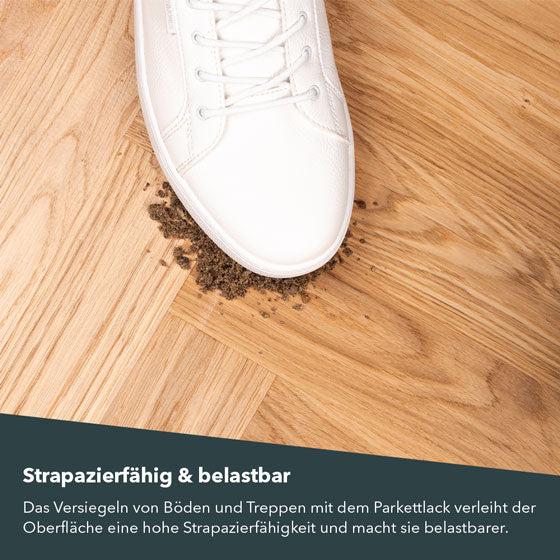 Weißer Schuh tritt auf gestrichenes Parkett und verteilt Dreck