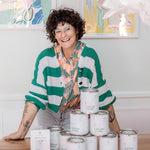 Partnerin Anne Werner steht lachend hinter einer Pyramide aus Dosen der Nubilli Edition