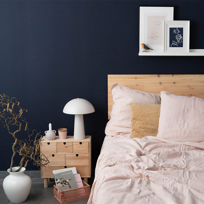 Wand hinter dem Bett in Dunkelbau gestrichen
