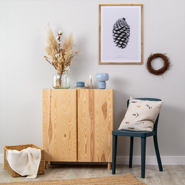 Grau gestrichene Wand mit einem Wandbild und einer hölzernen IKEA Ivar Kommode