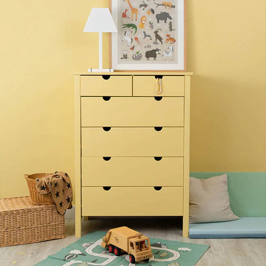 Kinderzimmer mit gelb gestrichener Wand und gelber Kommode