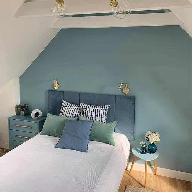 Blaue Wand hinter einem Bett