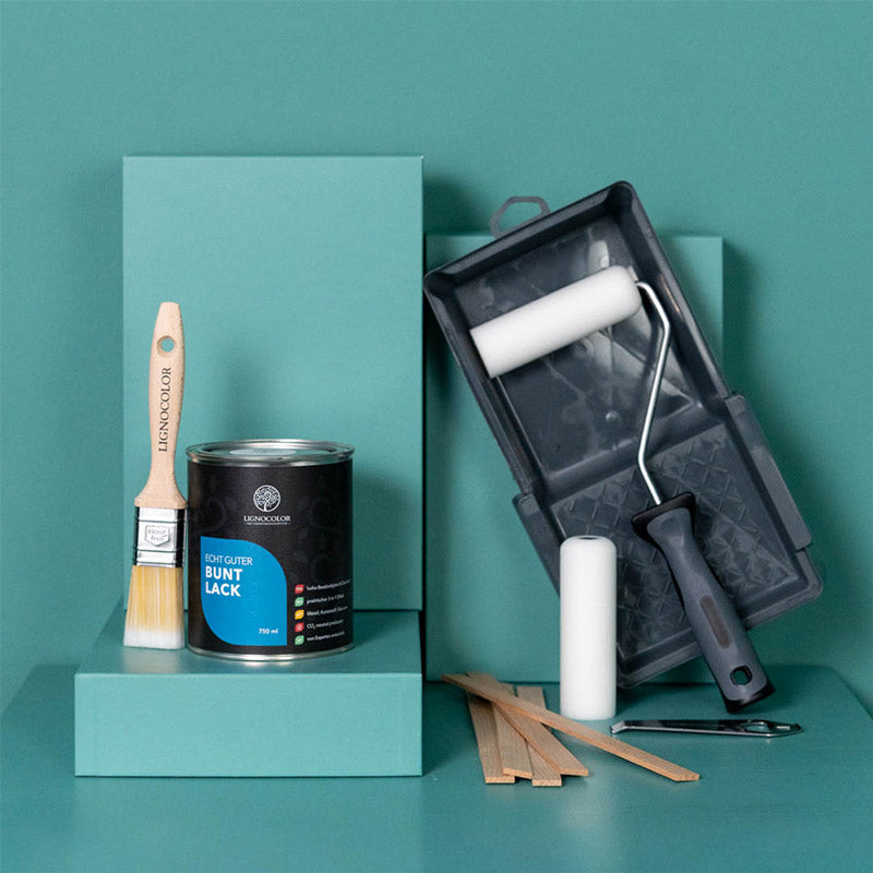 Buntlack Dose und passendes Zubehör vor einem grünen Hintergrund